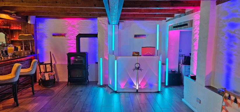 Moderne Bar mit bunten LED-Lichtern, Holzdecke und stilvollem Interieur.