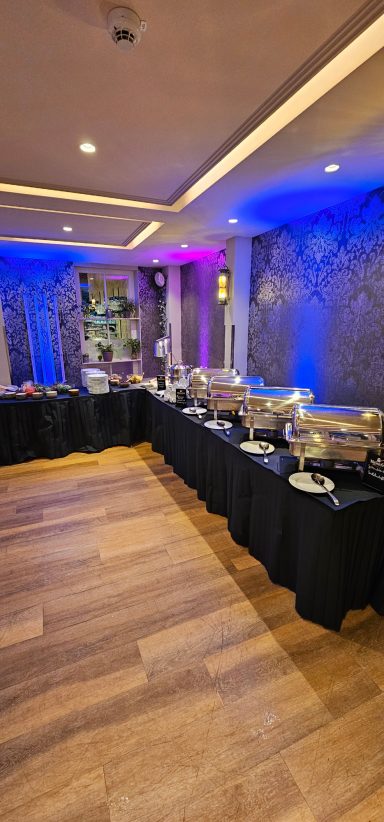 Ein elegantes Buffet in einem stilvollen Raum mit gedeckten Tischen und dekorativen Lichtern.