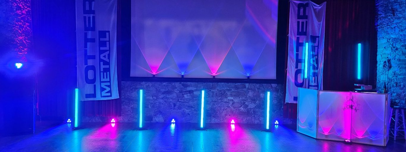 Bühne mit farbiger Beleuchtung in Blau und Pink, vorbereitet für eine DJ Firmenveranstaltung im Kloster Nimbschen.