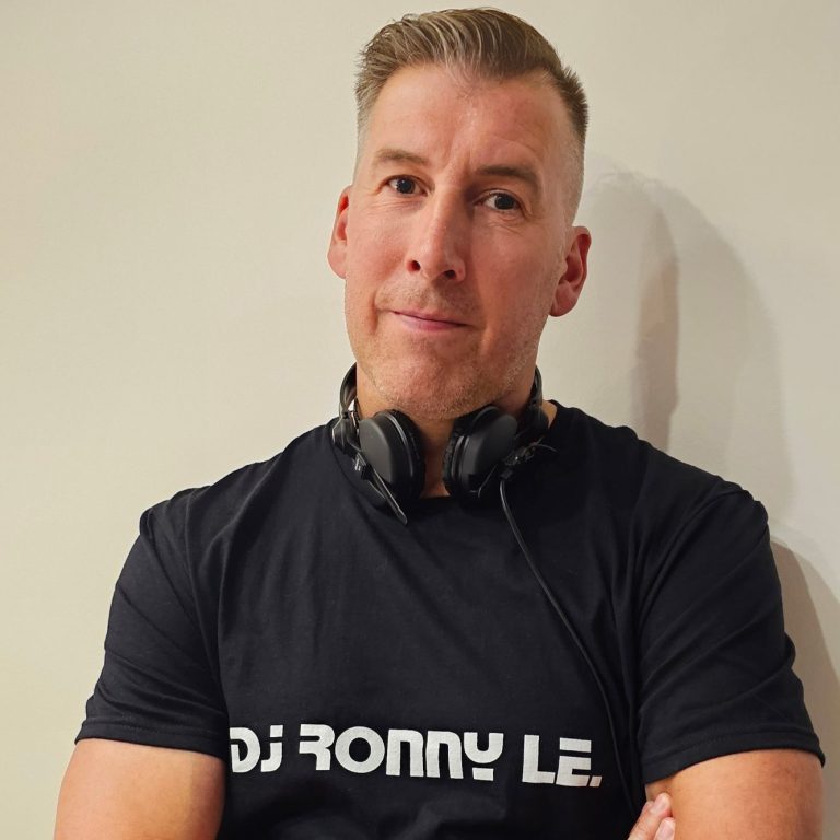 Mann mit Kopfhörern, T-Shirt mit „DJ RONNY LE“, verschränkt die Arme.