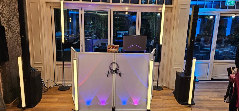 DJ-Deck mit Lautsprechern und bunten Lichtern in einer eleganten Veranstaltungslocation.